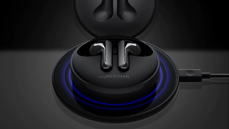 Qora simsiz quvvatlash maydonida quvvatlagichni ochib, moviy nur taratayotgan qora LG TONE Free FN6 tasviri