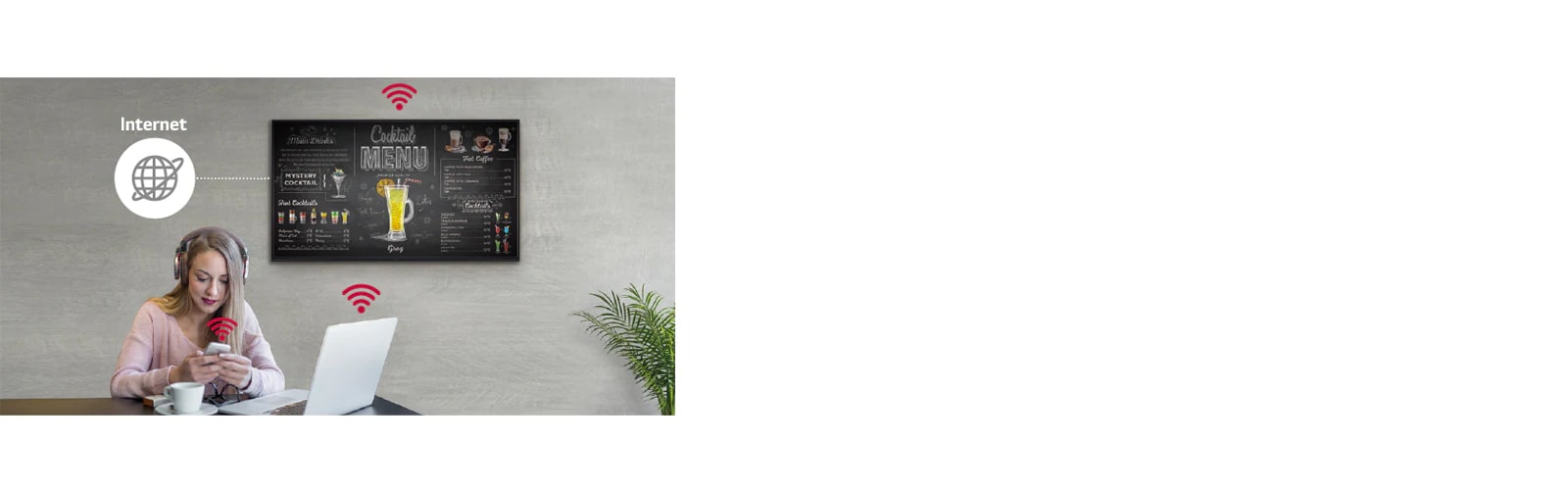 UR3J seriyasi devorga oʻrnatilgan, bir ayol shaxsiy kompyuteri va mobil telefonidan foydalanmoqda. Ushbu rasmda viveska simsiz tarmoq orqali uning qoʻlida turgan shaxsiy kompyuter va mobil telefonga ulanishi mumkinligi koʻrsatilgan.