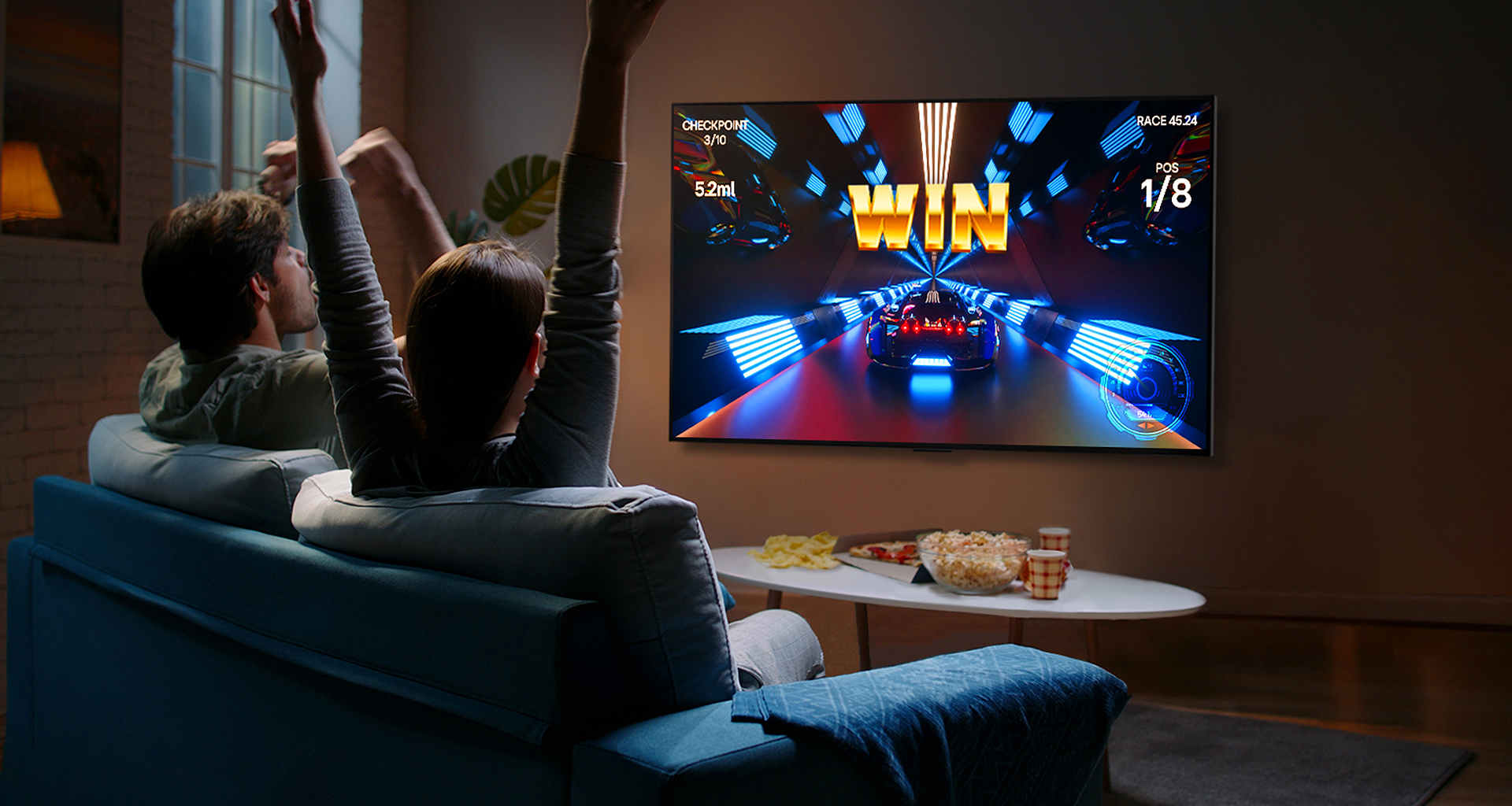 Odamlar kontroller yordamida LG OLED televizorida oʻyin oʻynamoqdalar
