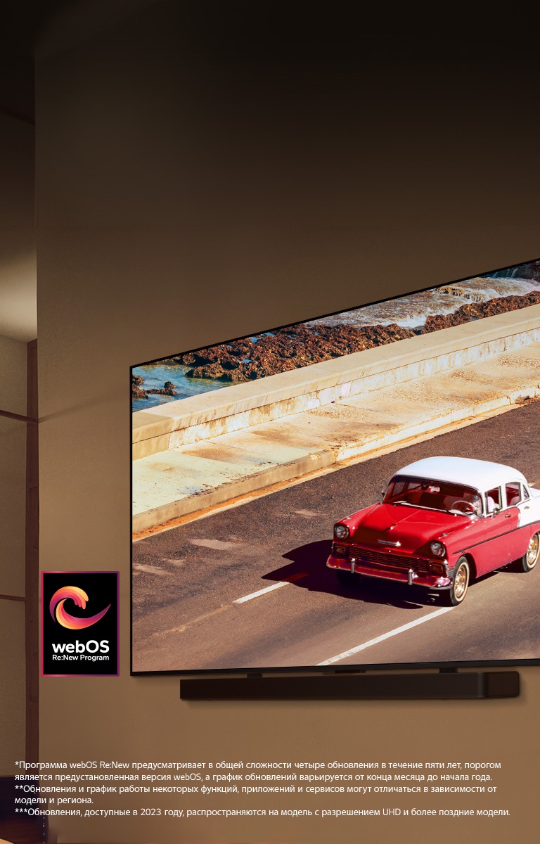 Телевизор LG QNED TV и звуковая панель Soundbar установлены на стене в мягко освещенной комнате. На экране телевизора демонстрируется красный автомобиль на дороге. Логотип webOS Re:New Program на изображении. Сообщение об отказе от ответственности: «Программа webOS Re:New предусматривает в общей сложности четыре обновления в течение пяти лет, порогом является предустановленная версия webOS, а график обновлений варьируется от конца месяца до начала года.» «Обновления и график работы некоторых функций, приложений и сервисов могут отличаться в зависимости от модели и региона.»