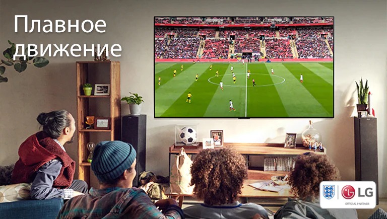 Четыре человека смотрят футбол на телевизоре в гостиной.