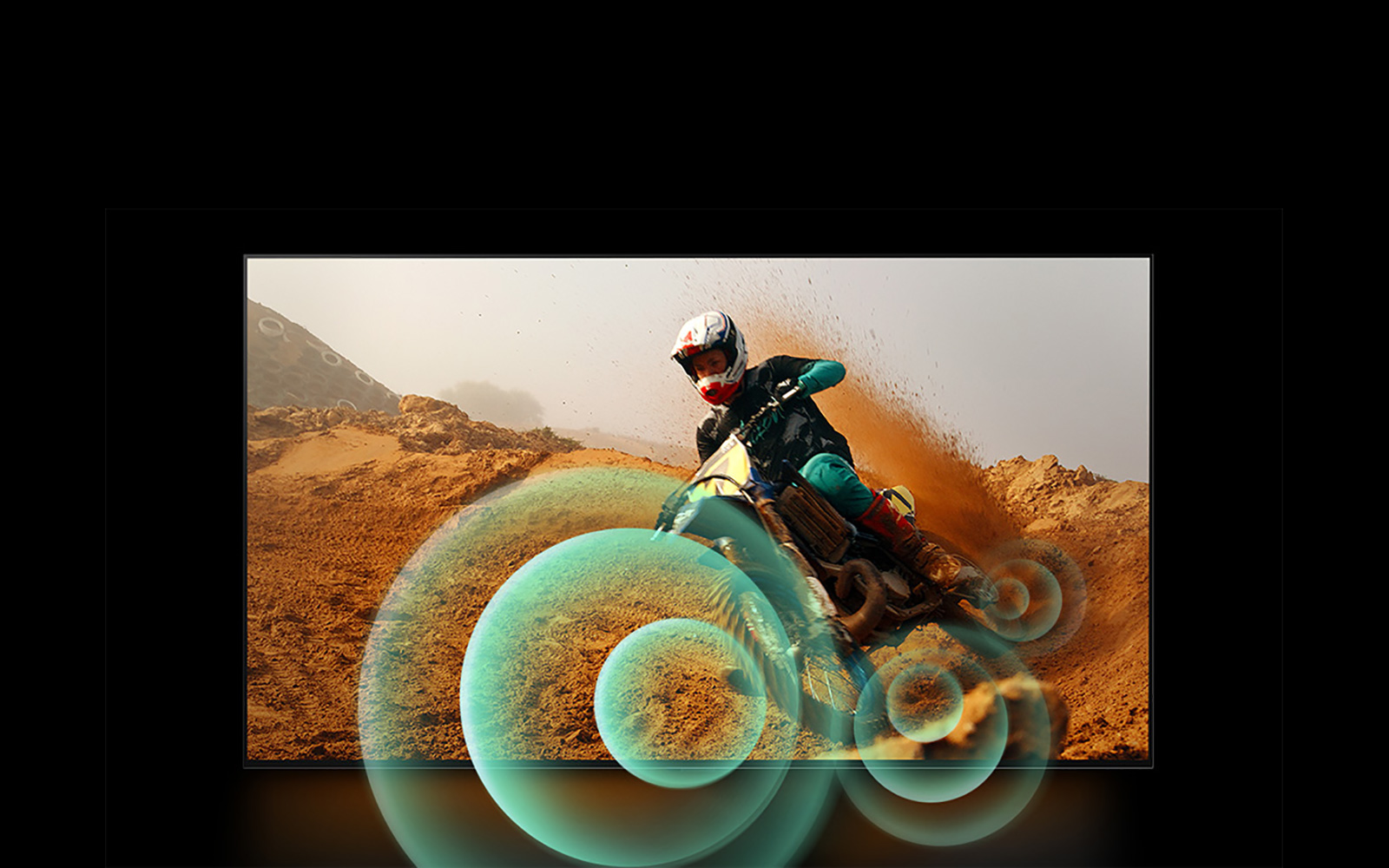 Мужчина едет на мотоцикле по грунтовой дороге с яркой круговой графикой вокруг мотоцикла.
