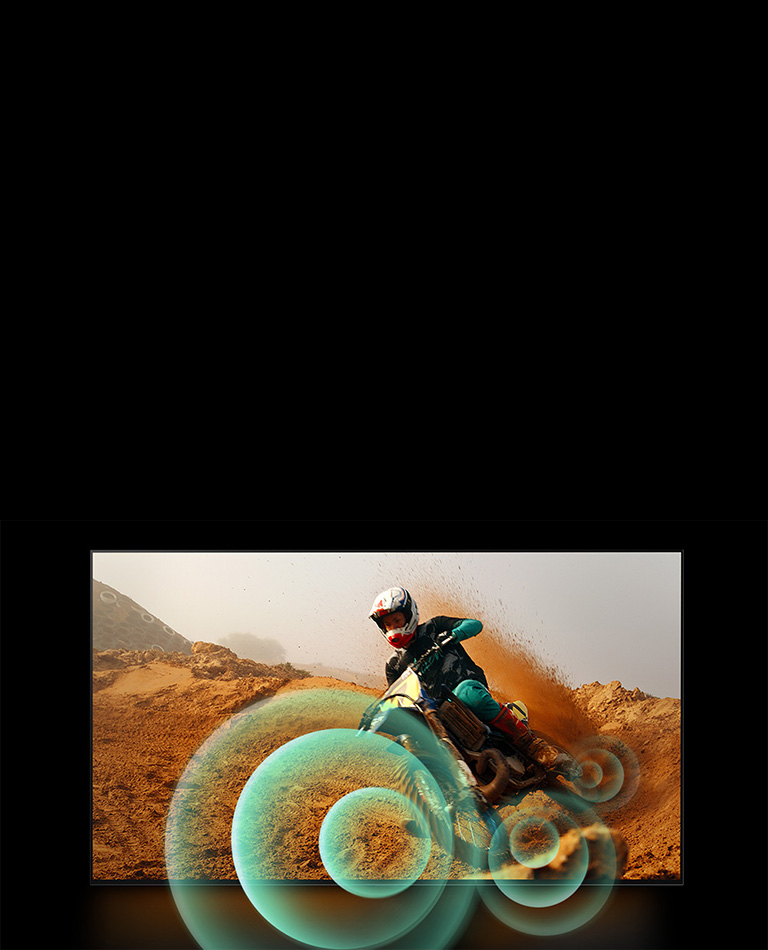 Мужчина едет на мотоцикле по грунтовой дороге с яркой круговой графикой вокруг мотоцикла.