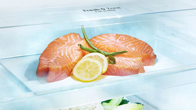 Ящик внутри холодильника lg с верхней морозильной камерой предназначен для лучшего сохранения продуктов, таких как мясо и рыба, без необходимости замораживания и размораживания. Здесь представлен кусок лосося с гарниром из лимона и зелени.	