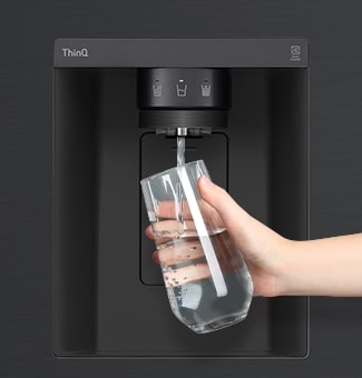Lấy nước vào cốc từ máy lọc nước của tủ lạnh