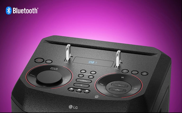 Cận cảnh các nút điều khiển của LG XBOOM ở mặt trên, với hai USB đã cắm vào. Logo Bluetooth được in ở góc trên bên trái.