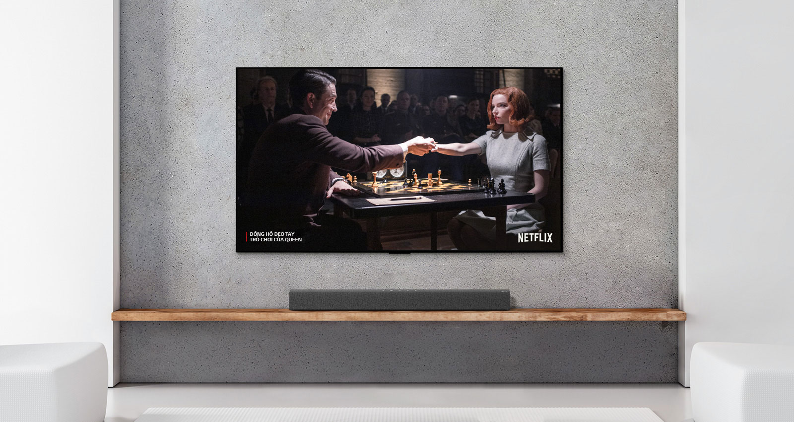 A soundbar and TV are in a white living room. A woman and a man are playing chess on TV screen.