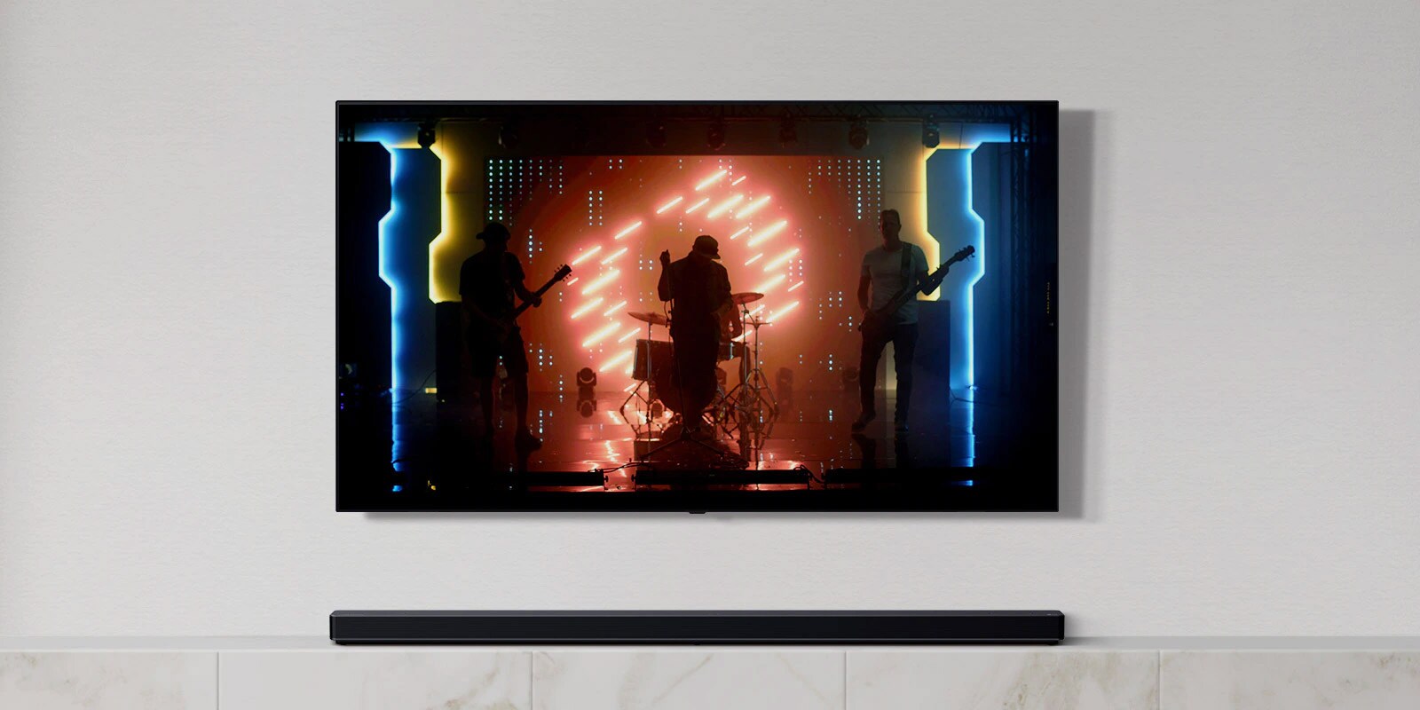 TV và loa soundbar trong phòng khách màu trắng. Một ban nhạc đang chơi nhạc cụ và hát trên màn hình TV. (phát video)