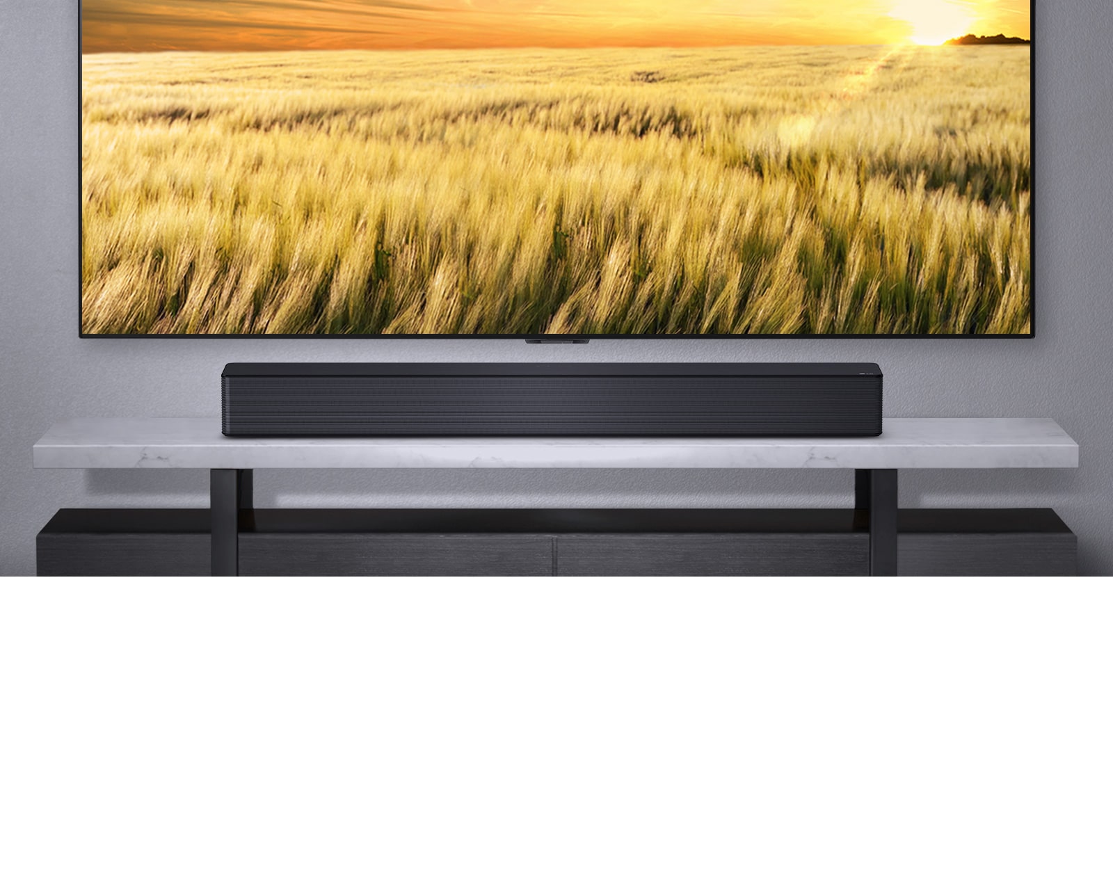 Một chiếc TV treo trên tường màu xám và loa LG Soundbar đặt bên dưới trên một chiếc kệ xám. Đĩa Blue-Ray cất bên dưới kệ.