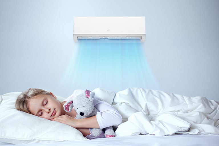 The air conditioner is operating. Below it, a girl is sleeping comfortably holding a doll.