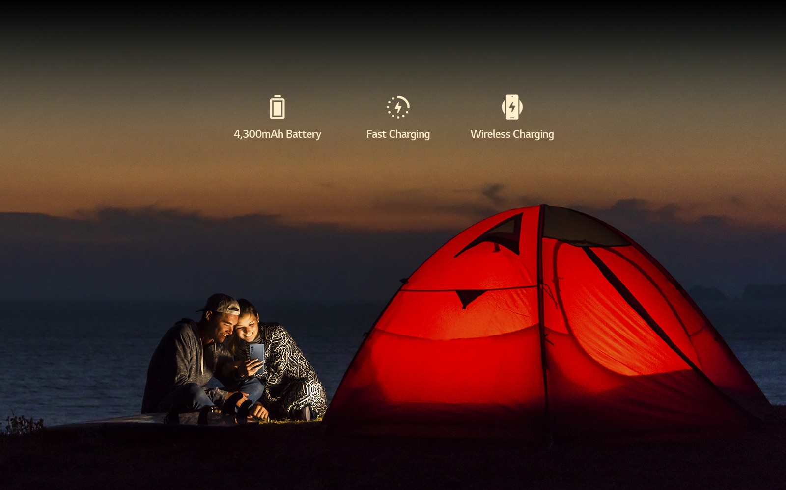 A couple in front of tent at night.