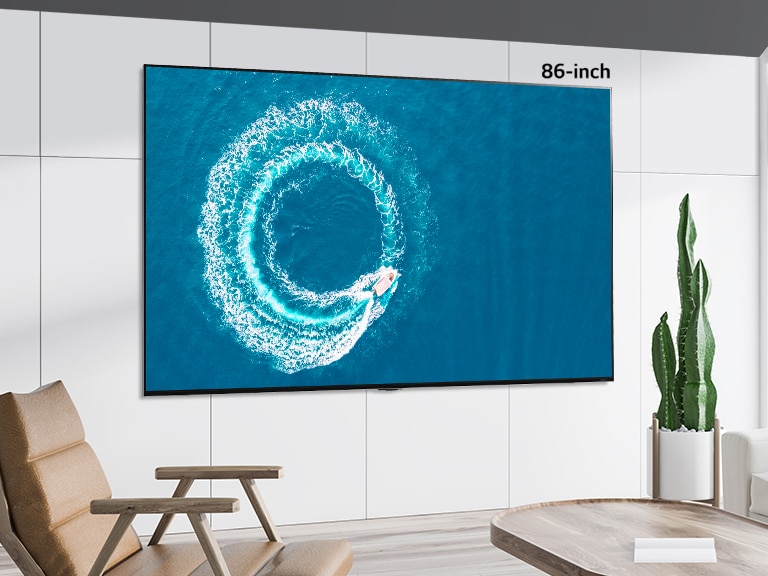 LG QNED MiniLED TV wall mounted in a modern, white space. Scrolling left-right shows the difference in size between a 43-inch and 86-inch screen.