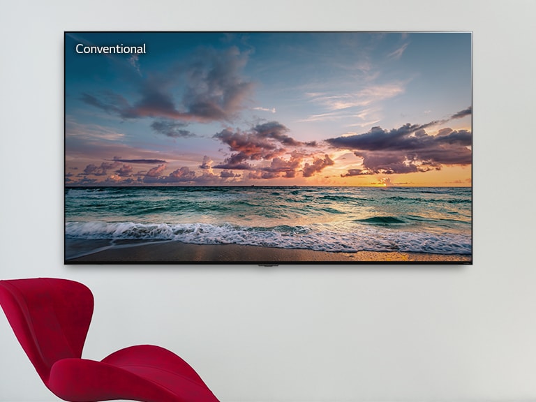 A large-screen wall mounted TV with a red chair in front. The screen shows waves gently breaking on a beach. Scrolling from left to right shows the difference in color on a conventional LCD TV versus LG QNED MiniLED.