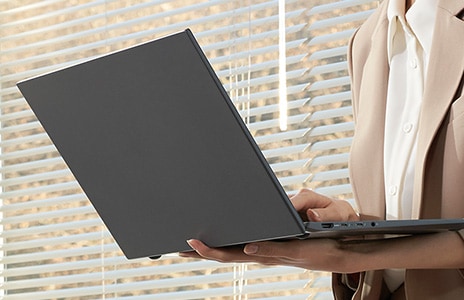 Laptop in hands of user walking while using it.