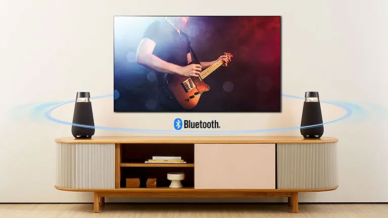 Dos XO3 están colocados en el estante del televisor. Se están conectando a la TV con Bluetooth y mostrando la onda de sonido por toda la sala de estar.