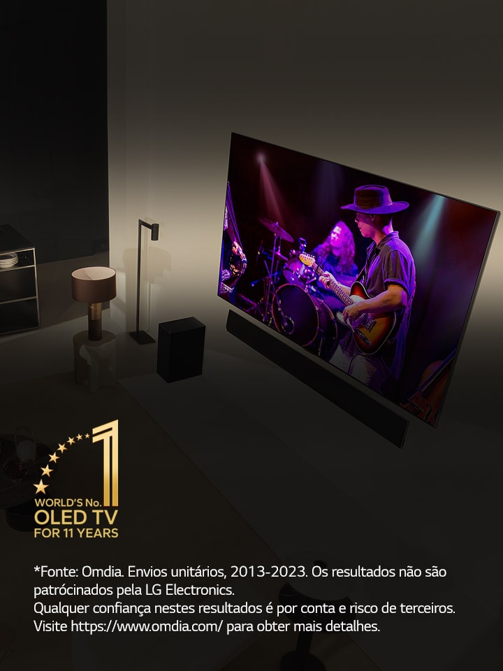 Uma perspetiva aérea de um homem e uma mulher a assistir a um concerto numa grande OLED TV num apartamento moderno. Aparece na imagem o emblema "A OLED TV número 1 do mundo há 11 anos". Uma declaração de isenção de responsabilidade diz o seguinte: “Fonte: Omdia. Envios unitários, 2013 a 2023. Os resultados não são patrocinados pela LG Electronics. Qualquer confiança nestes resultados é por conta e risco de terceiros. Visite https://www.omdia.com/ para obter mais detalhes.”