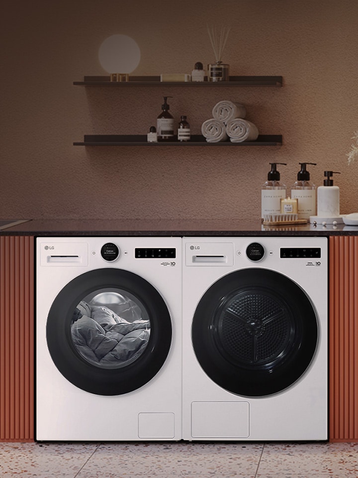 LG washing machine and dryer installed under a countertop in a laundry space with shelves and decorative items
