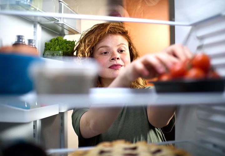 A woman demonstrates how to store food in the fridge correctly