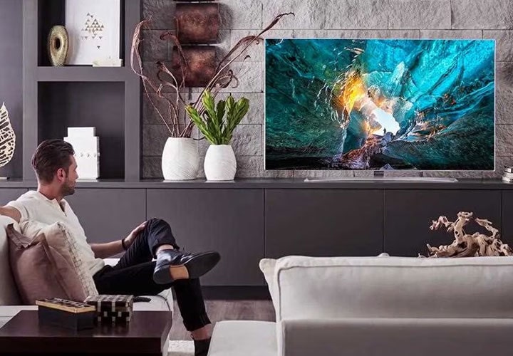 A man and lg signature wallpaper tv w7 in a living room.