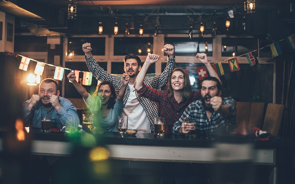 A group of friends watch the big game at home with an LG TV and soundbar