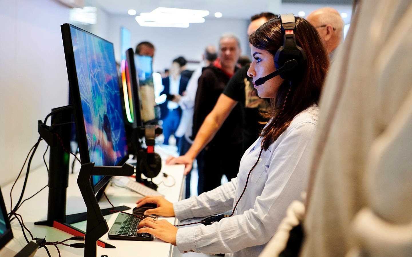 IFA 2018: A woman plays video games on an LG monitor, amongst the crowd at the exhibition 