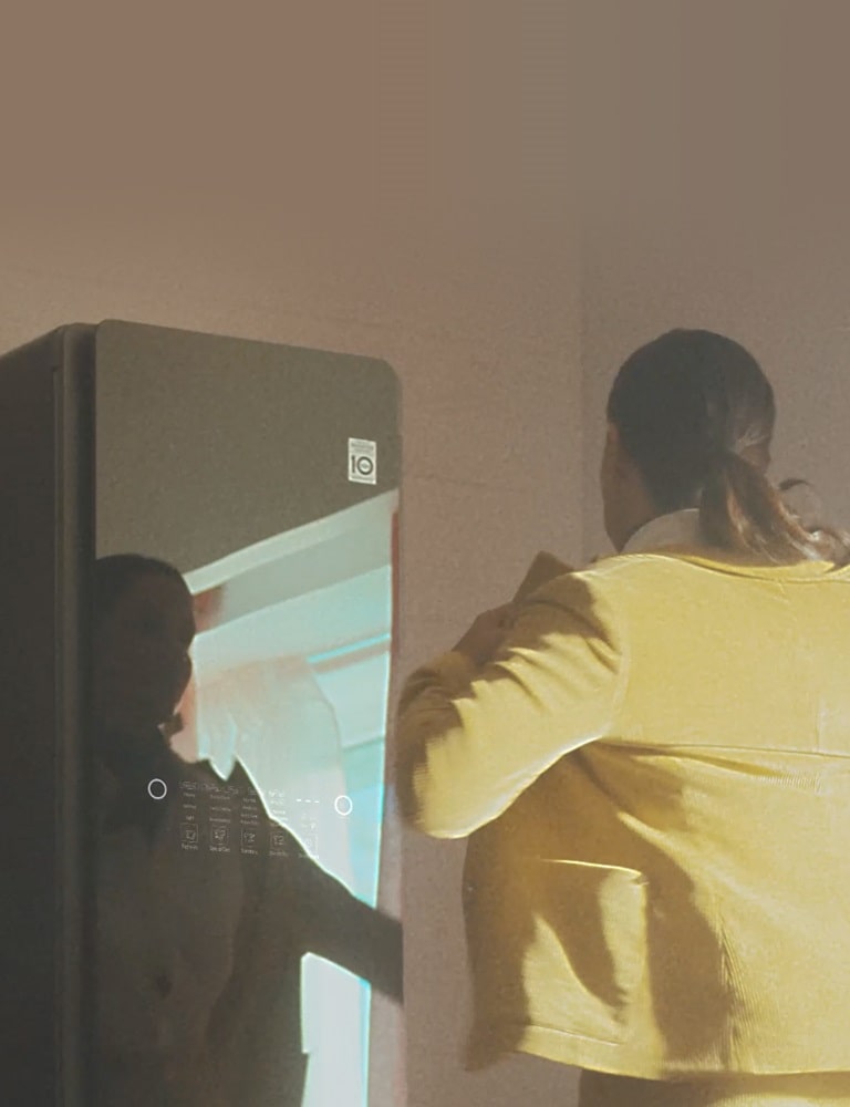 Woman taking her jacket from the Styler to go for work.