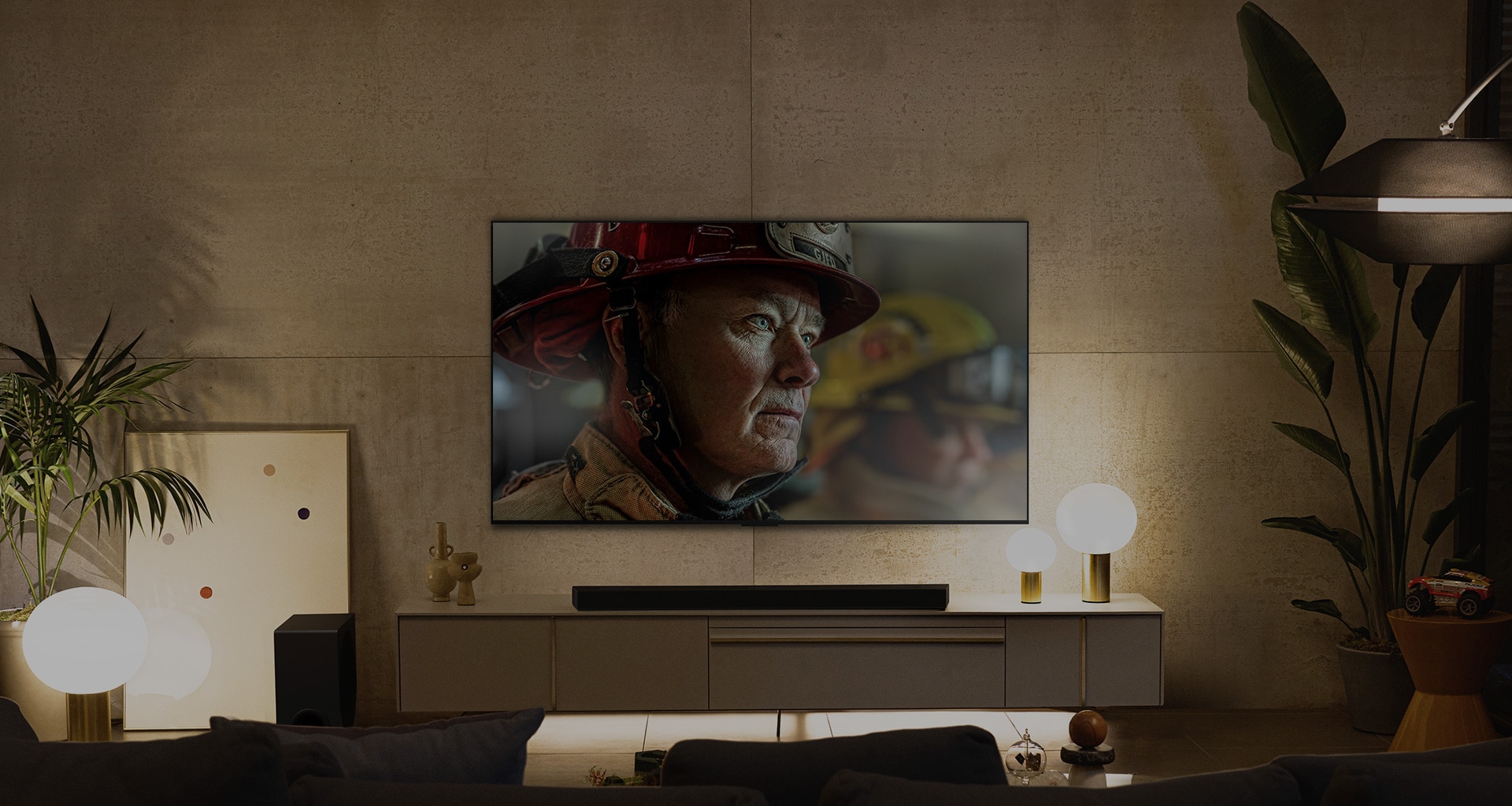 A wall-mounted LG OLED TV is in a white and bright room with natural decorations. As the screen moves, the scene changes from day to night. with Dolby Vision IQ logo