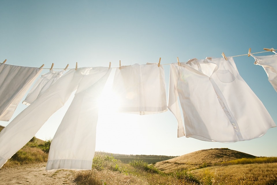 Bílé oblečení visící na prádelní šňůře