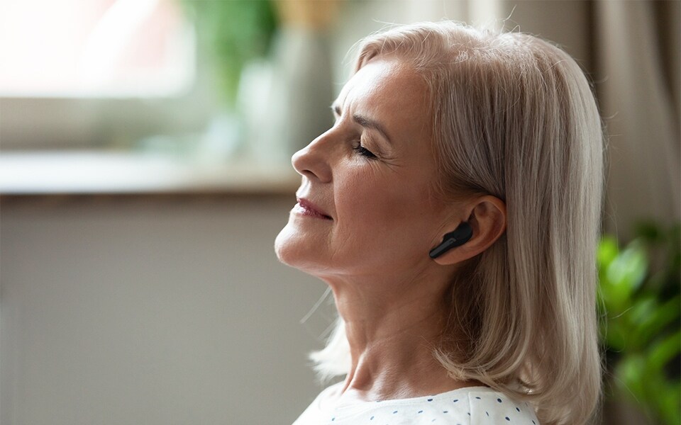 Mum relaxes with her noise-cancelling earbuds.