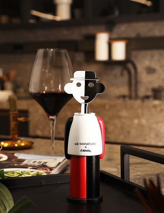 Der Korkenzieher von LG SIGNATURE mit dem Design von Alessandro Mendini zusammen mit einem Weinglas.