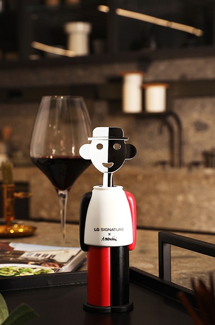 Der Korkenzieher von LG SIGNATURE mit dem Design von Alessandro Mendini zusammen mit einem Weinglas.