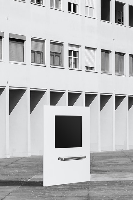 Der LG SIGNATURE OLED TV W hängt vor einem Gebäude mit unzähligen Fenstern an einer Wand.