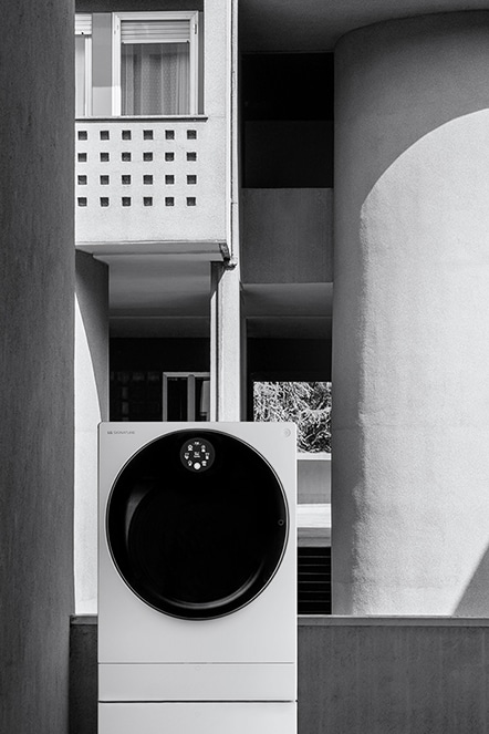 Die LG SIGNATURE Waschmaschine steht vor einem Gebäude mit einer hohen Säule.