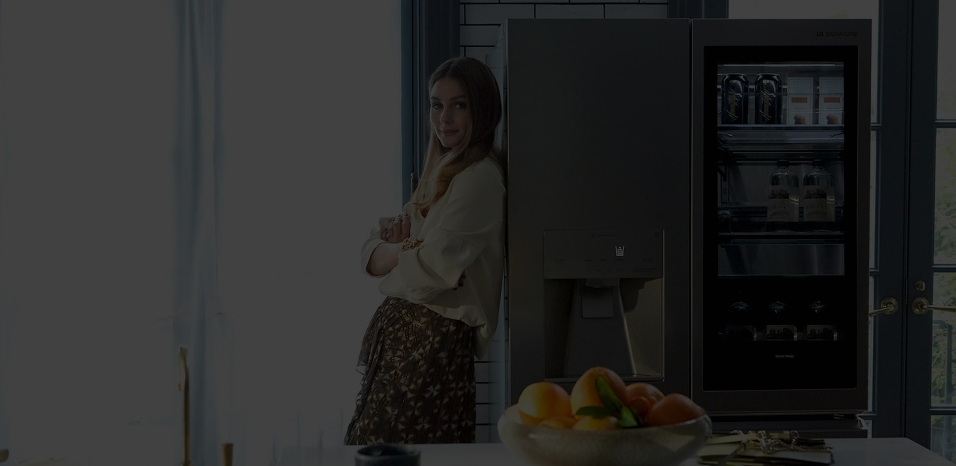 Olivia Palermo leans against the LG SIGNATURE Refrigerator.